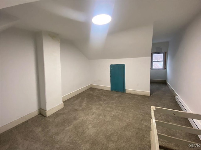 additional living space with dark carpet and vaulted ceiling