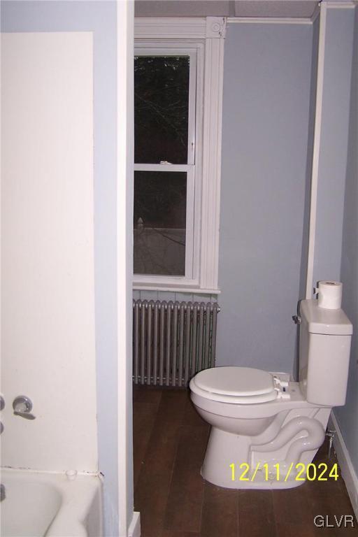 bathroom featuring radiator heating unit and toilet