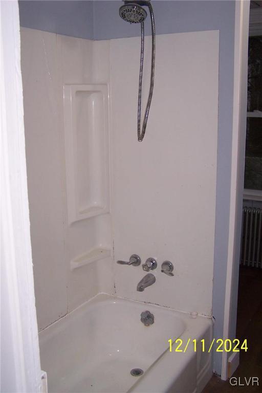 bathroom featuring radiator heating unit and shower / bathtub combination