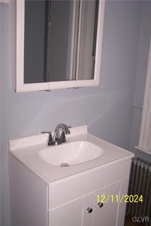 bathroom with radiator heating unit and vanity