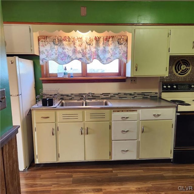 kitchen featuring dark hardwood / wood-style flooring, tasteful backsplash, white appliances, sink, and white cabinetry