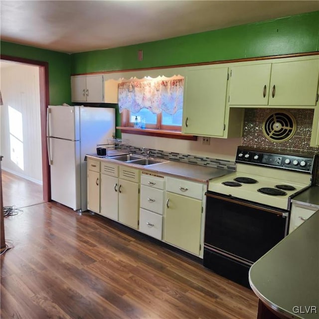 kitchen with tasteful backsplash, white appliances, dark wood-type flooring, sink, and white cabinetry