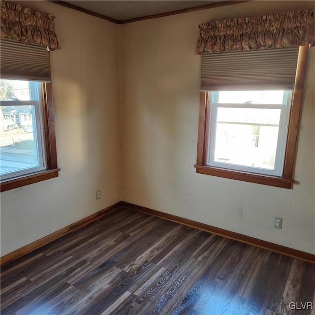 spare room featuring crown molding and dark hardwood / wood-style floors