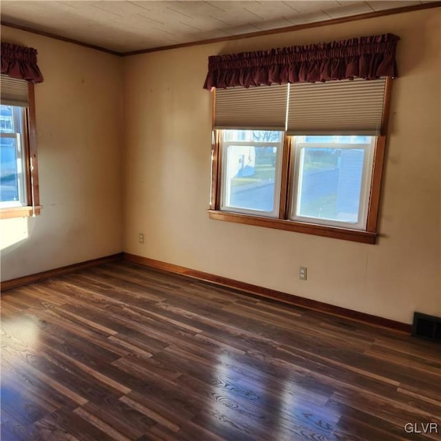 spare room featuring dark hardwood / wood-style floors and crown molding