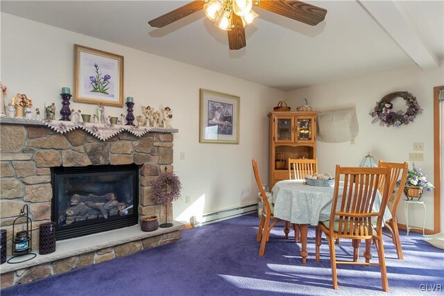 dining area featuring baseboard heating, a ceiling fan, carpet flooring, and a stone fireplace