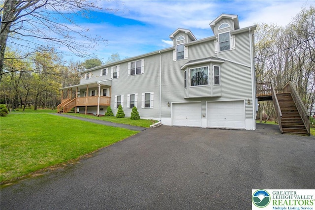 view of front of home featuring stairs, a garage, a front lawn, and driveway