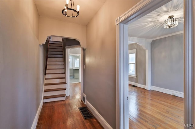 corridor featuring wood-type flooring and crown molding