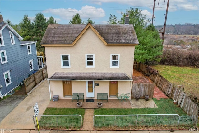 view of front of house with a front yard, central AC unit, and a patio area