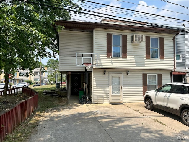 view of front of property with an AC wall unit