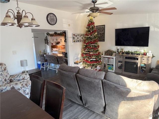 living room with hardwood / wood-style floors and ceiling fan with notable chandelier