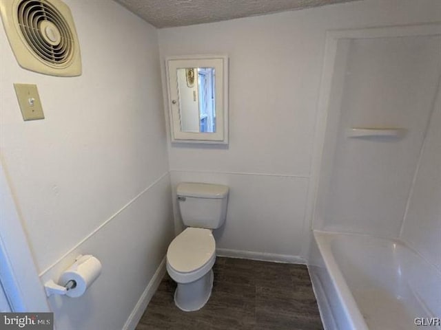 bathroom featuring a textured ceiling and toilet