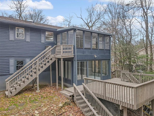 rear view of house featuring a wooden deck and a sunroom