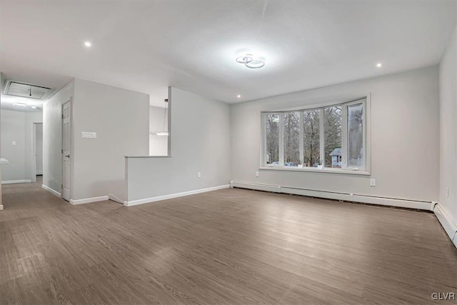 spare room featuring dark hardwood / wood-style floors and a baseboard heating unit