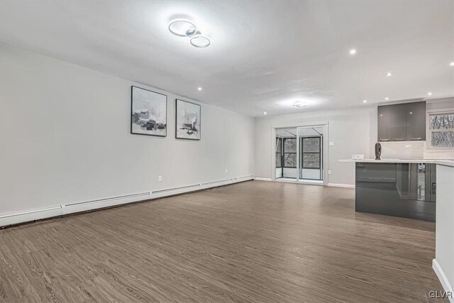 unfurnished living room featuring a baseboard radiator and dark wood-type flooring