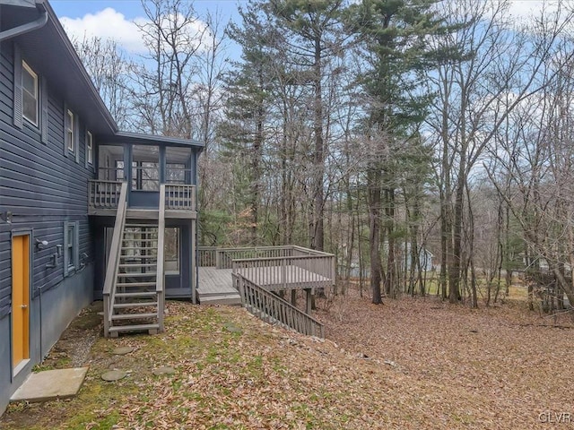 view of yard featuring a sunroom and a wooden deck