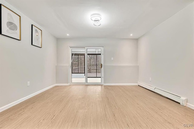 empty room with baseboard heating and light wood-type flooring