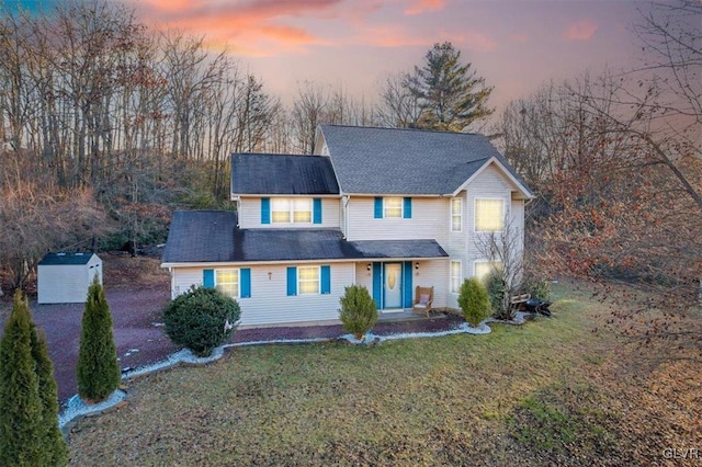 view of front of house with a garage, an outdoor structure, and a lawn