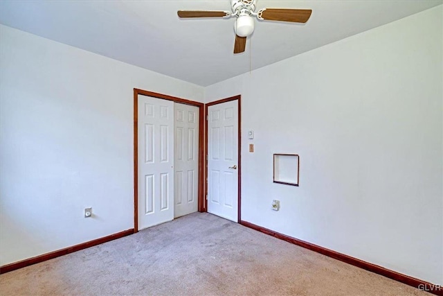 unfurnished bedroom featuring ceiling fan, a closet, and light colored carpet