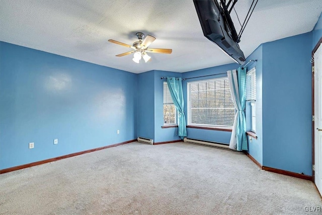 spare room with ceiling fan, light colored carpet, a textured ceiling, and a baseboard heating unit