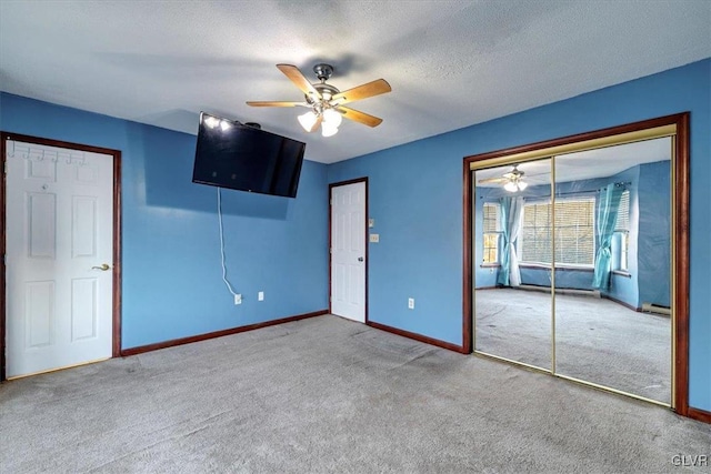 unfurnished bedroom featuring light carpet, a textured ceiling, and ceiling fan