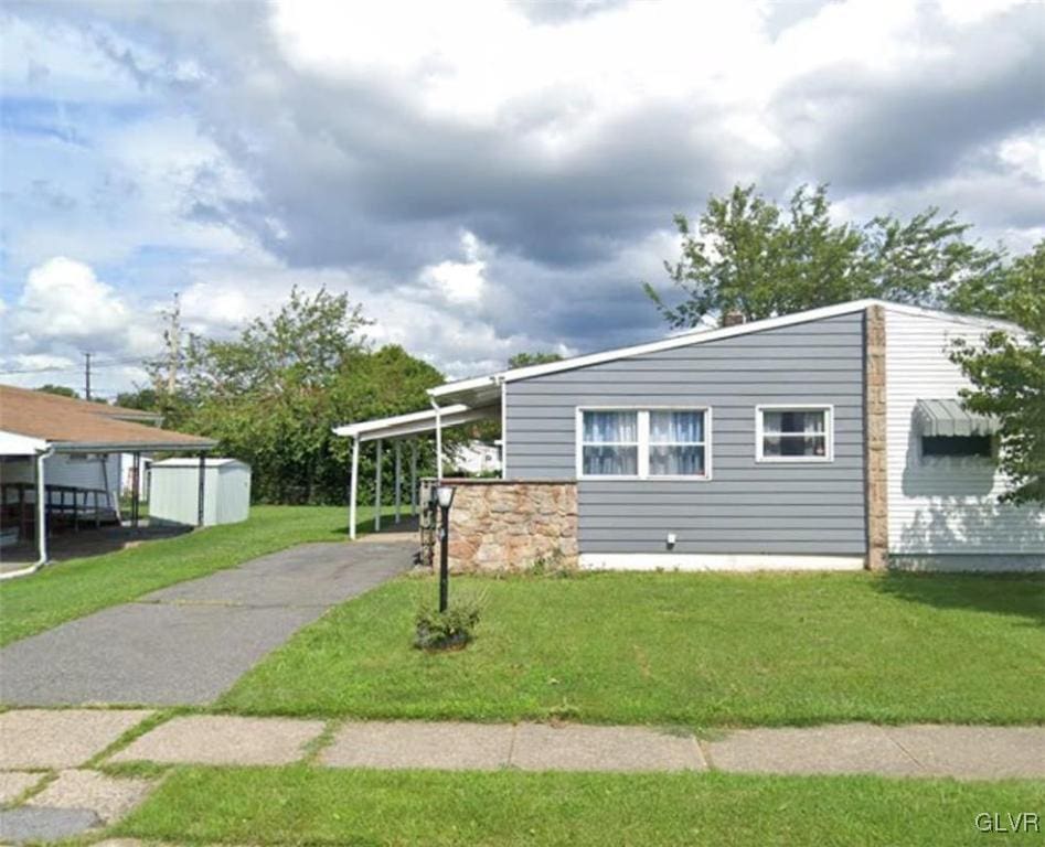 view of side of home featuring a lawn and a carport