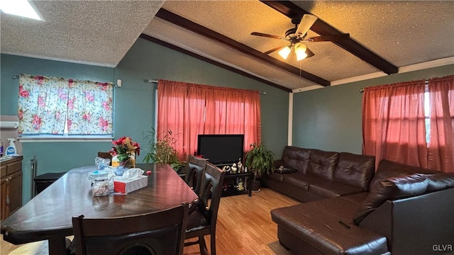 dining area featuring vaulted ceiling with beams, light hardwood / wood-style flooring, a textured ceiling, and ceiling fan