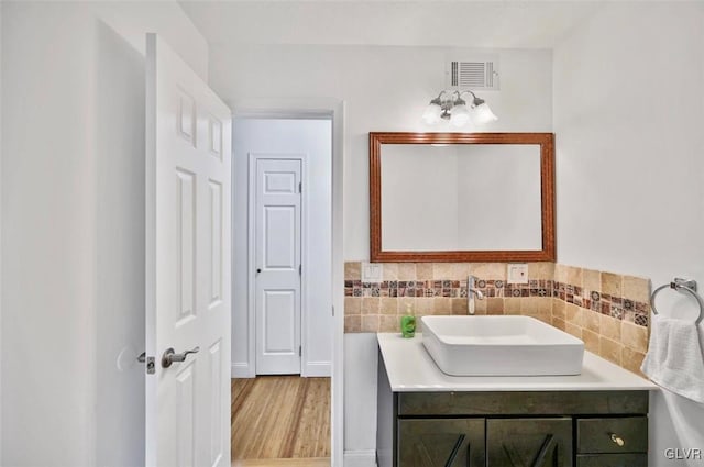 bathroom featuring vanity, decorative backsplash, and wood-type flooring