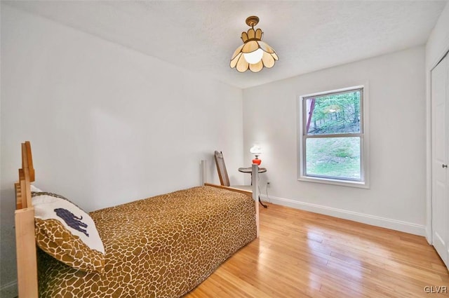 bedroom with a textured ceiling and hardwood / wood-style flooring