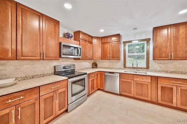 kitchen with backsplash, decorative light fixtures, sink, and stainless steel appliances