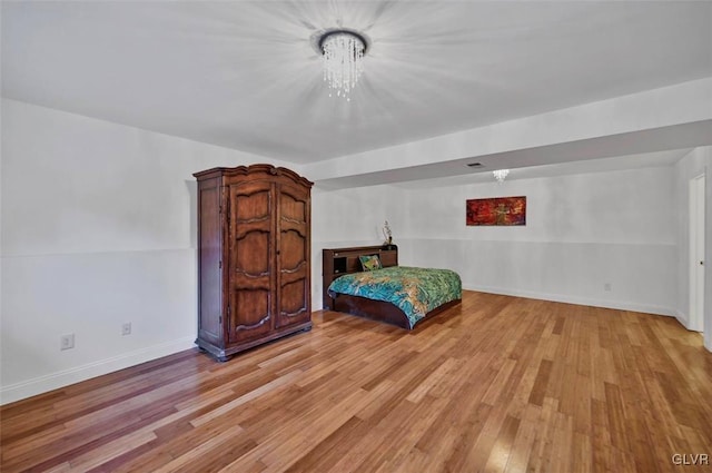 bedroom with a notable chandelier and light hardwood / wood-style floors