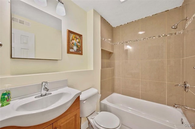 full bathroom featuring toilet, vanity, and tiled shower / bath