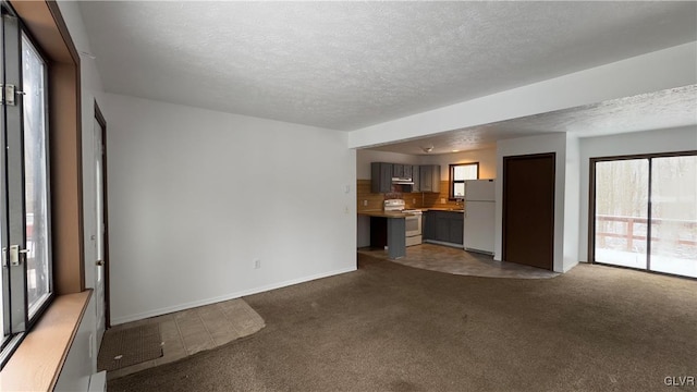 unfurnished living room with a textured ceiling and dark colored carpet