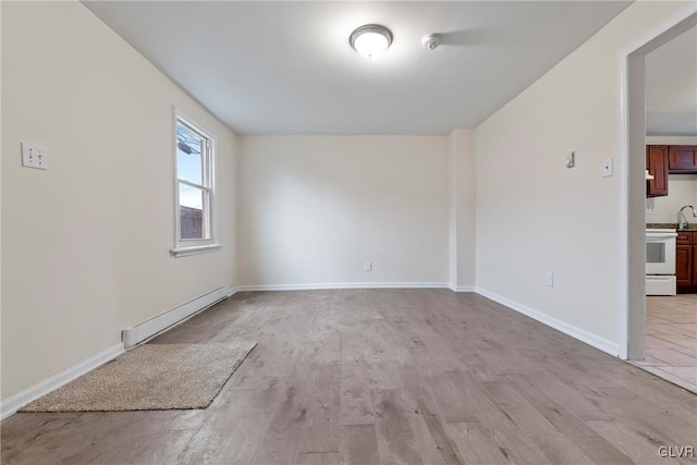 empty room with light hardwood / wood-style flooring and a baseboard heating unit