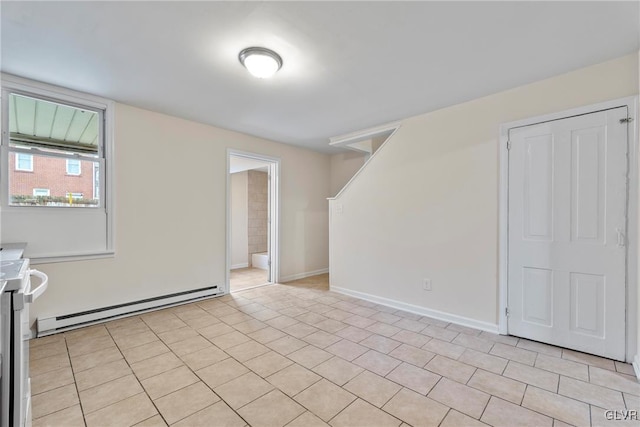 empty room featuring light tile patterned floors and a baseboard radiator