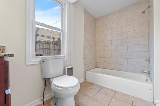 bathroom with tile patterned flooring, tiled shower / bath combo, and toilet