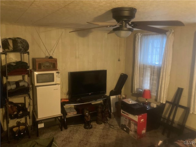 carpeted living room with ceiling fan