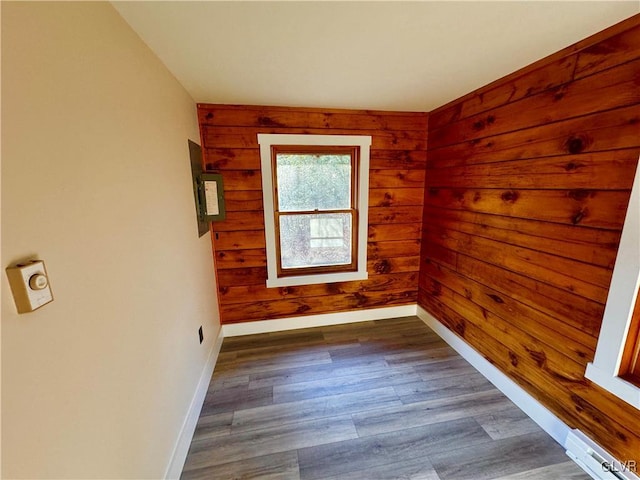 spare room with dark wood-type flooring and wooden walls