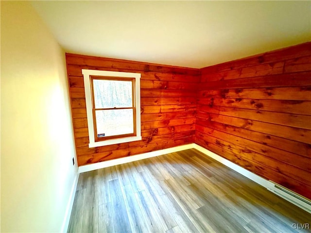 empty room with wood walls and wood-type flooring