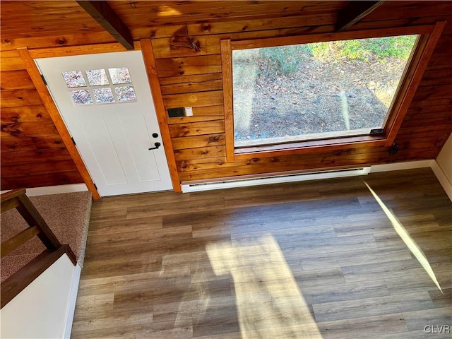 foyer entrance featuring beam ceiling, wooden walls, hardwood / wood-style flooring, and a baseboard heating unit