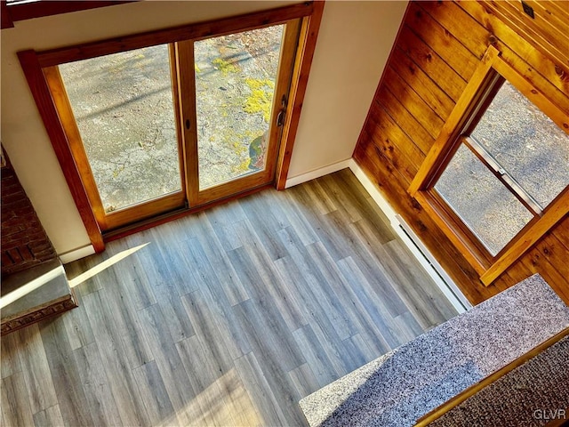 interior space featuring plenty of natural light, light wood-type flooring, and a baseboard heating unit