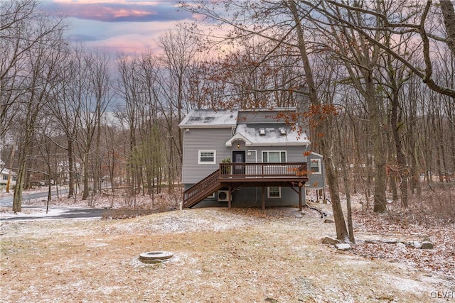 back house at dusk with a wooden deck