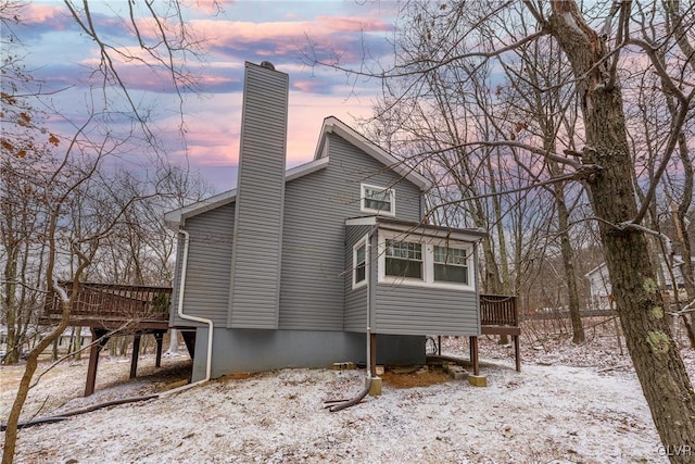 view of snow covered exterior featuring a wooden deck