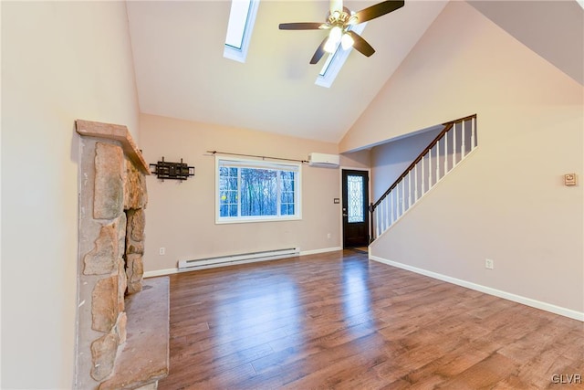 unfurnished living room with a wall mounted air conditioner, high vaulted ceiling, a skylight, ceiling fan, and a baseboard radiator