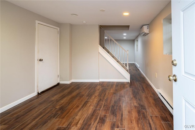 basement featuring dark hardwood / wood-style flooring, a wall mounted AC, and a baseboard heating unit