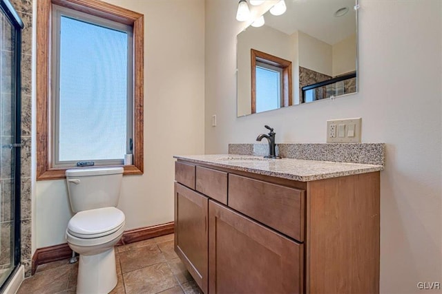 bathroom featuring a shower with door, vanity, and toilet