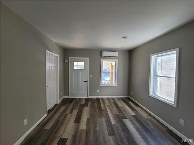 foyer featuring dark hardwood / wood-style floors, a wealth of natural light, and a wall mounted AC