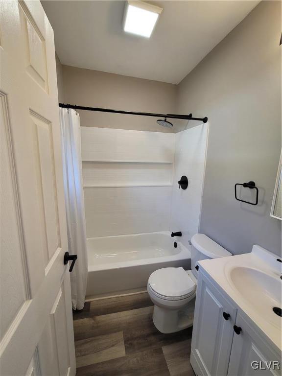 full bathroom with hardwood / wood-style floors, vanity, toilet, and shower / bath combo with shower curtain