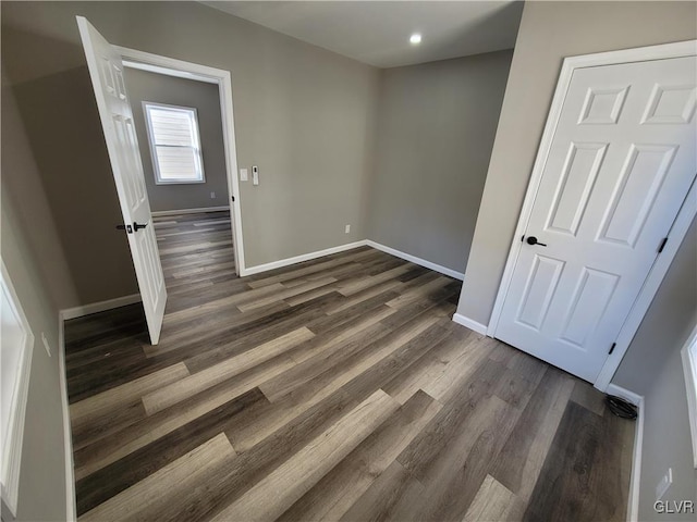 unfurnished bedroom featuring dark hardwood / wood-style flooring and a closet