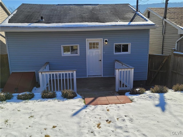 view of snow covered back of property