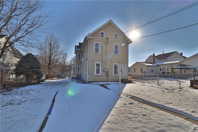 view of snow covered rear of property